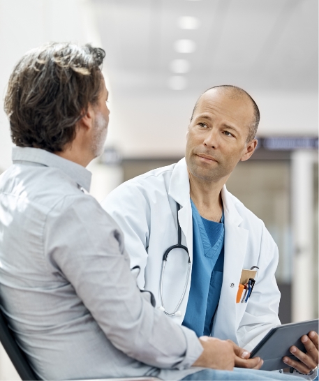Ein Arzt spricht im Wartezimmer mit einem Patienten