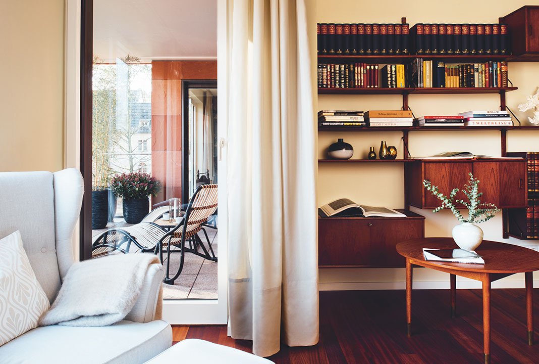 Blick aus einem Wohnzimmer auf ein Bücherregal und links daneben auf den Balkon